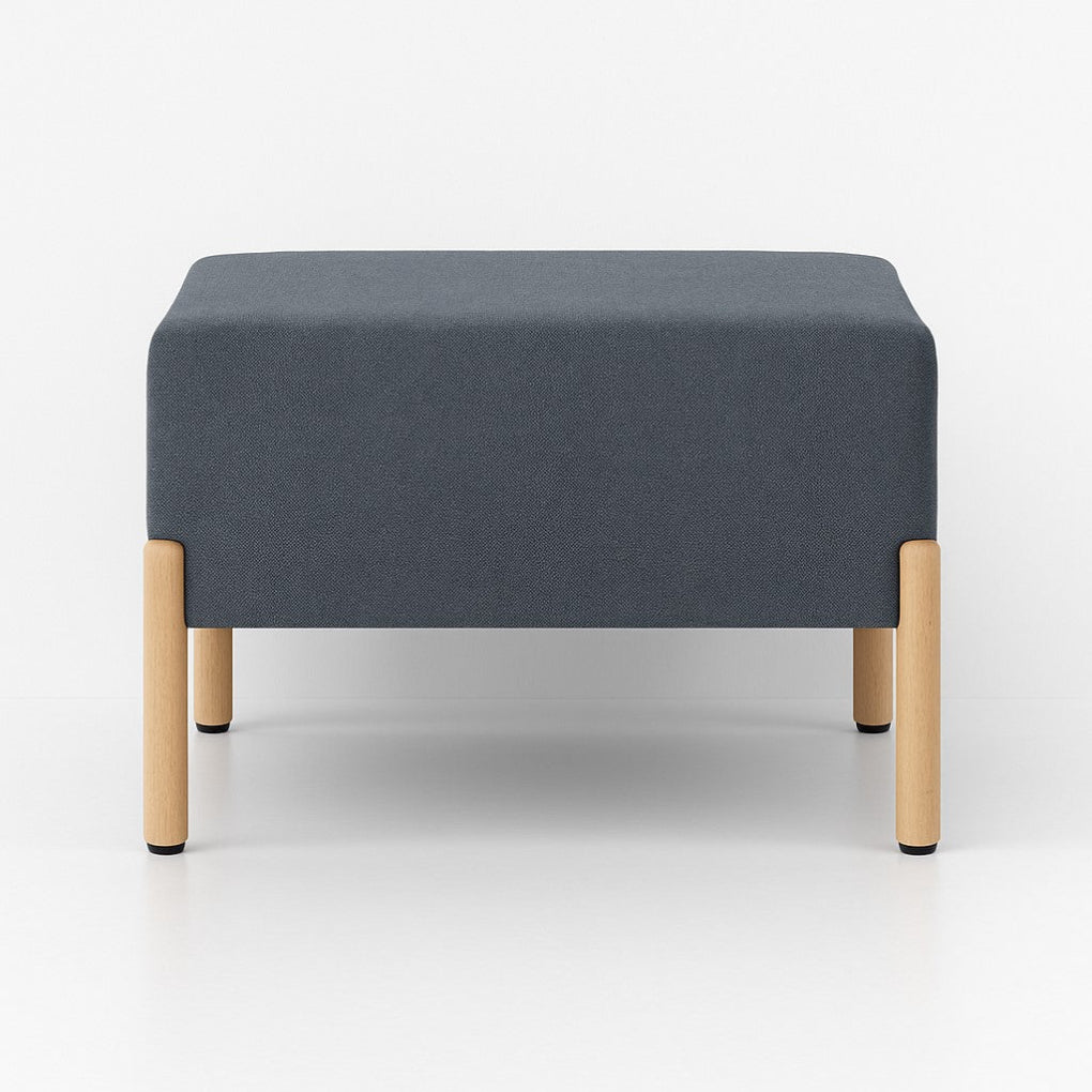 Porventura COD ottoman in dark grey Camira fabric, with a square cushioned seat and beech wood legs. Its simple proportions bring comfort and a refined character to contemporary interiors.