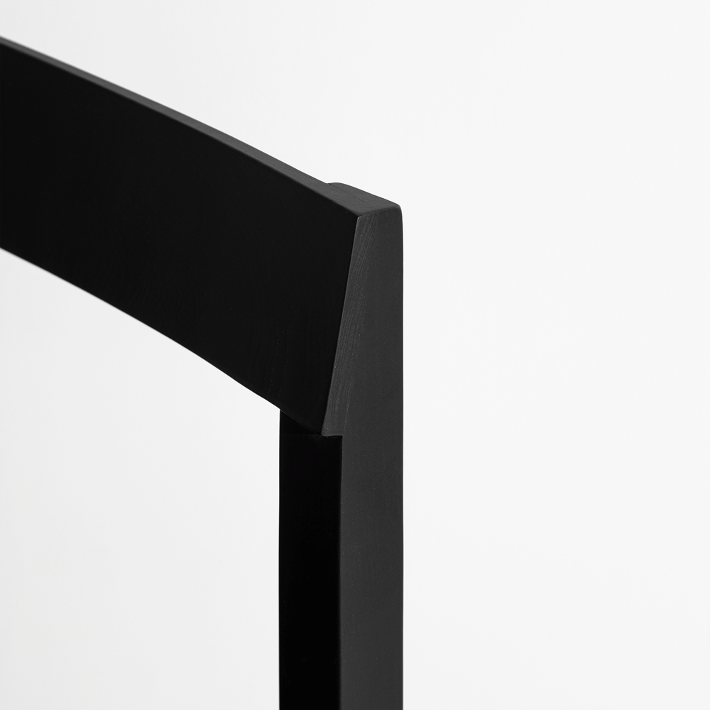 A cadeira formal da JBNG Studio apresenta um design elegante, assento almofadado e pés em madeira, ideal para ambientes sofisticados em casa ou no escritório.
