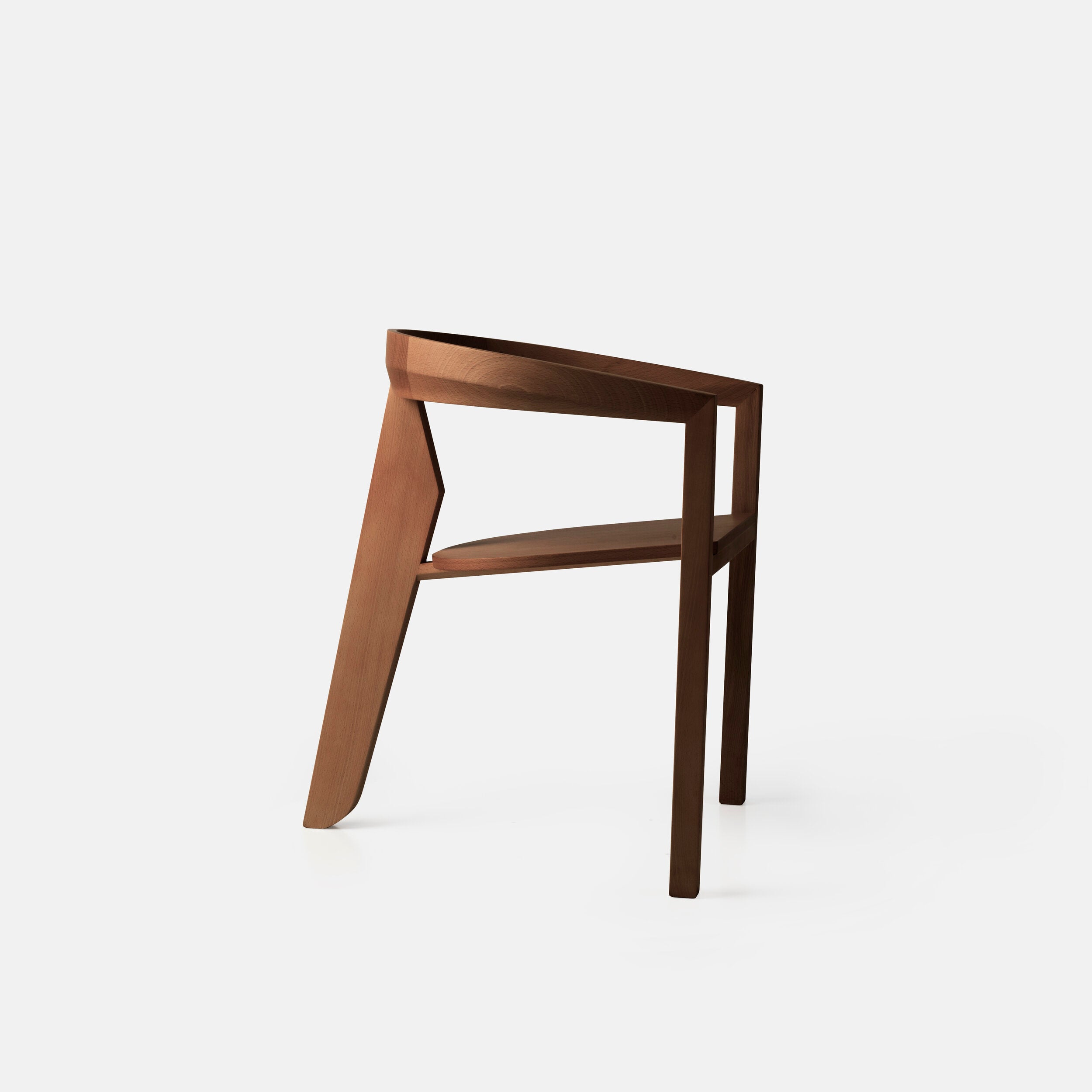 Porventura Icon chair with walnut finish, showcasing a modern, stylish wooden chair design in a natural setting.