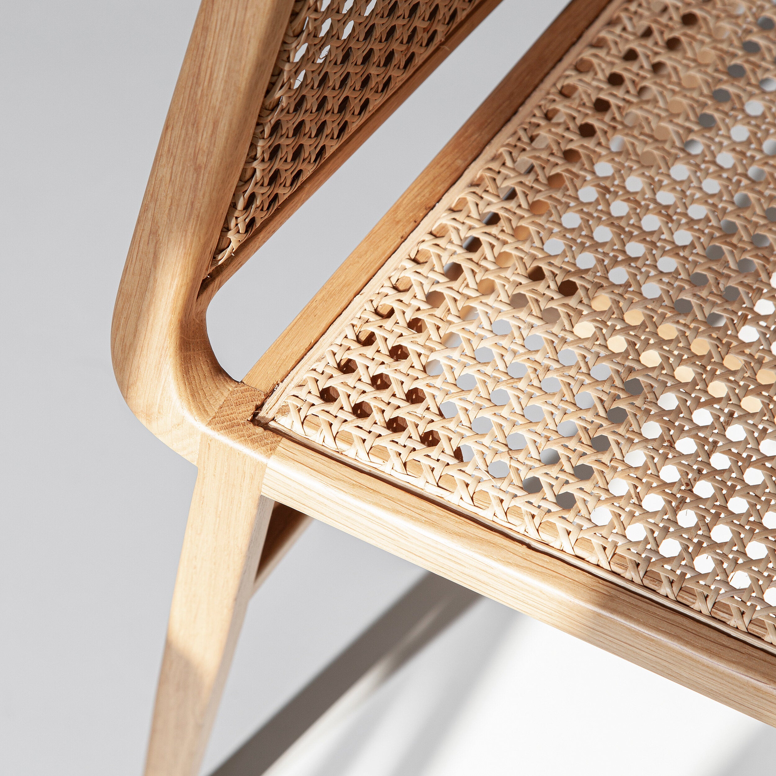 A cadeira Porventura Bee apresenta um design elegante e moderno, com um assento curvo e pés em madeira.