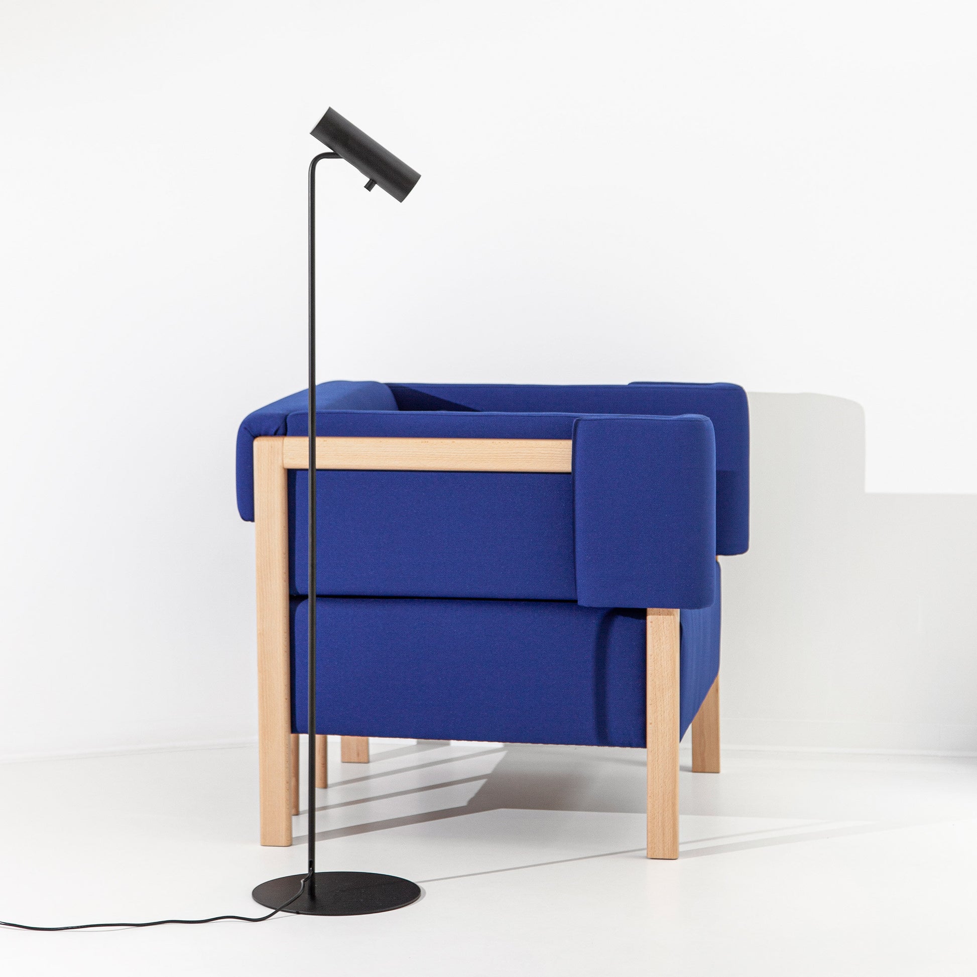 Sofá de um lugar Cod, da autoria de Filipa Aguiar e João Pereira, com um design moderno e estofos em tons neutros, numa sala de estar elegante.