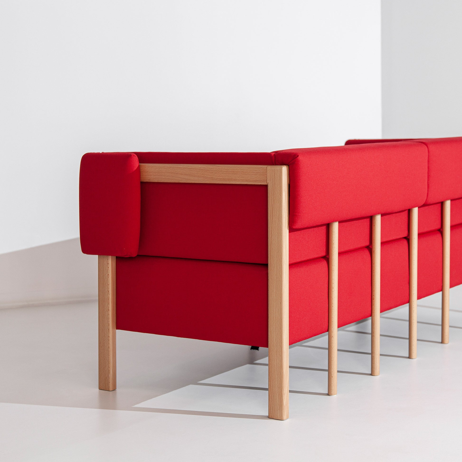 Sofá de três lugares Porventura Cod com tecido suave e design moderno, apresentado numa sala de estar acolhedora.