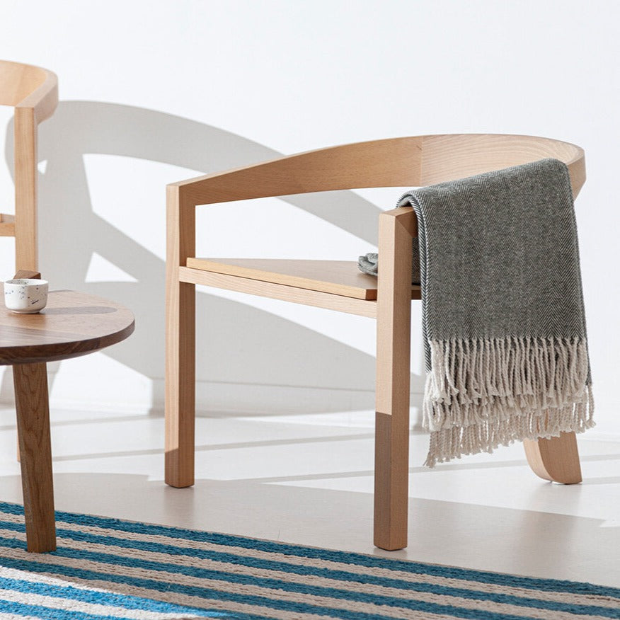 Poltrona Porventura Icon Lounge com estofos em tecido macio e design moderno, apresentada numa sala de estar acolhedora.