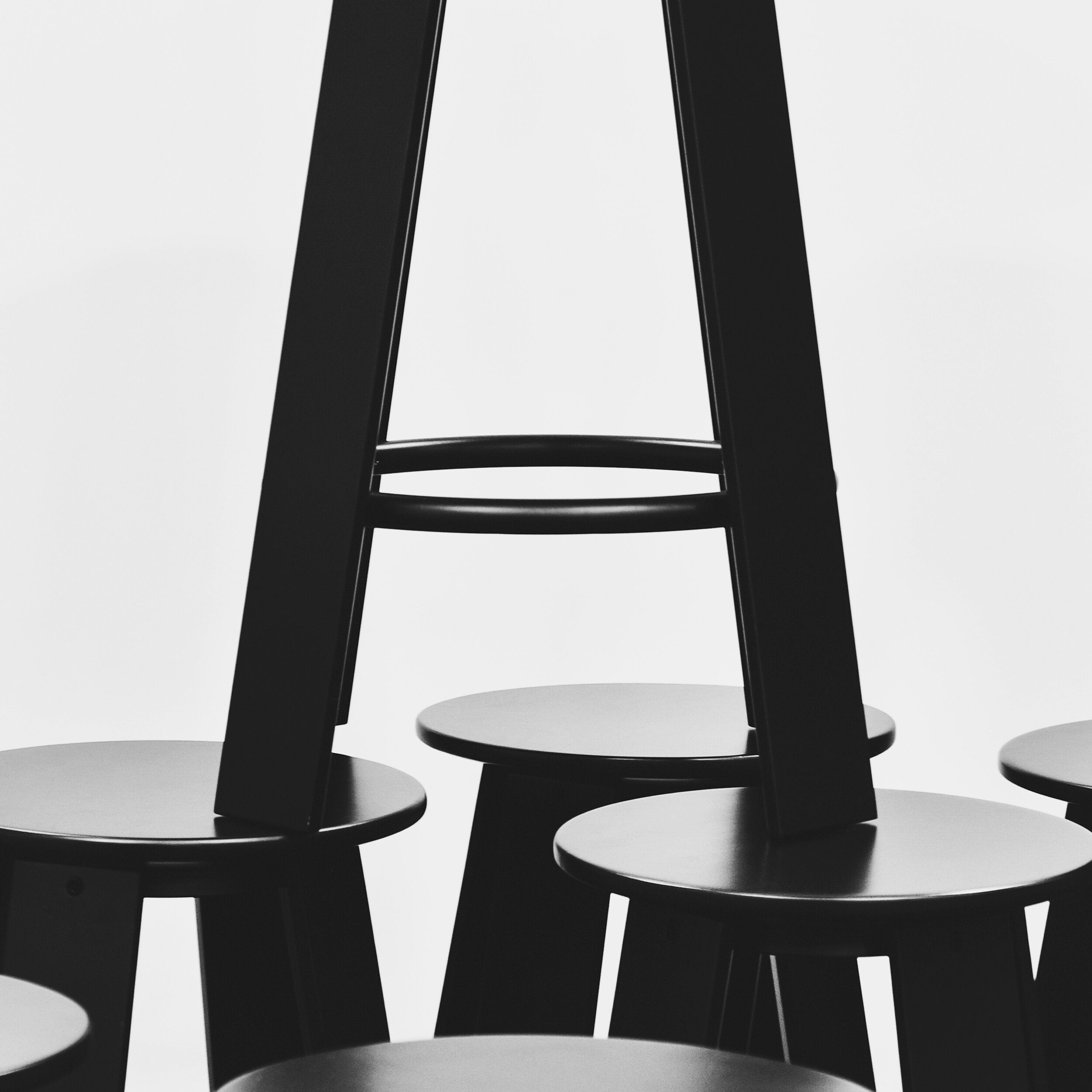 Banqueta linear Porventura com assento de madeira moderno e elegante e pés de metal sobre um fundo neutro.