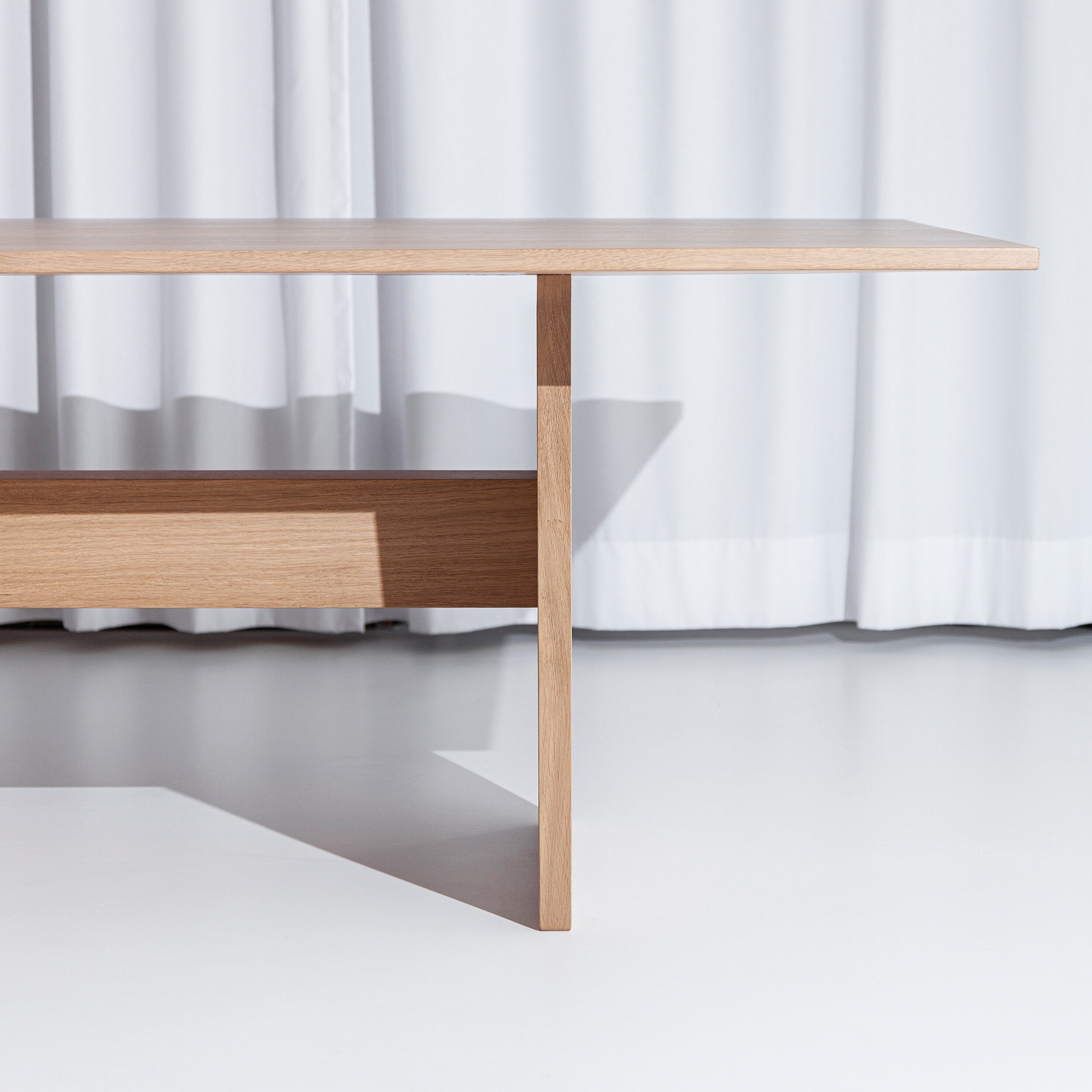 Porventura Nova table with sleek wooden surface and modern design, shown in a close-up view.