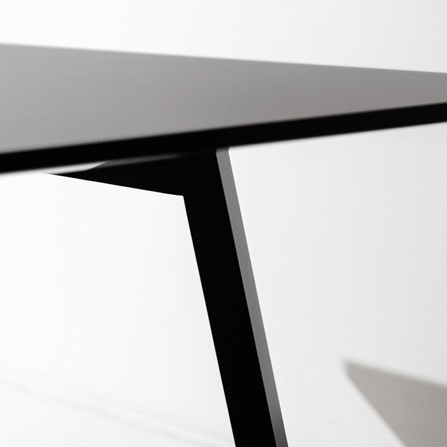 Mesa plana Porventura com um design elegante e minimalista, apresentando uma superfície lisa e pés robustos para espaços interiores modernos.
